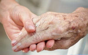 Image of a senior holding hands with younger person