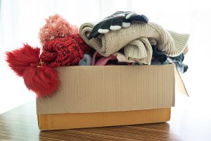 A box overflowing, ready to donate clothes to AKS